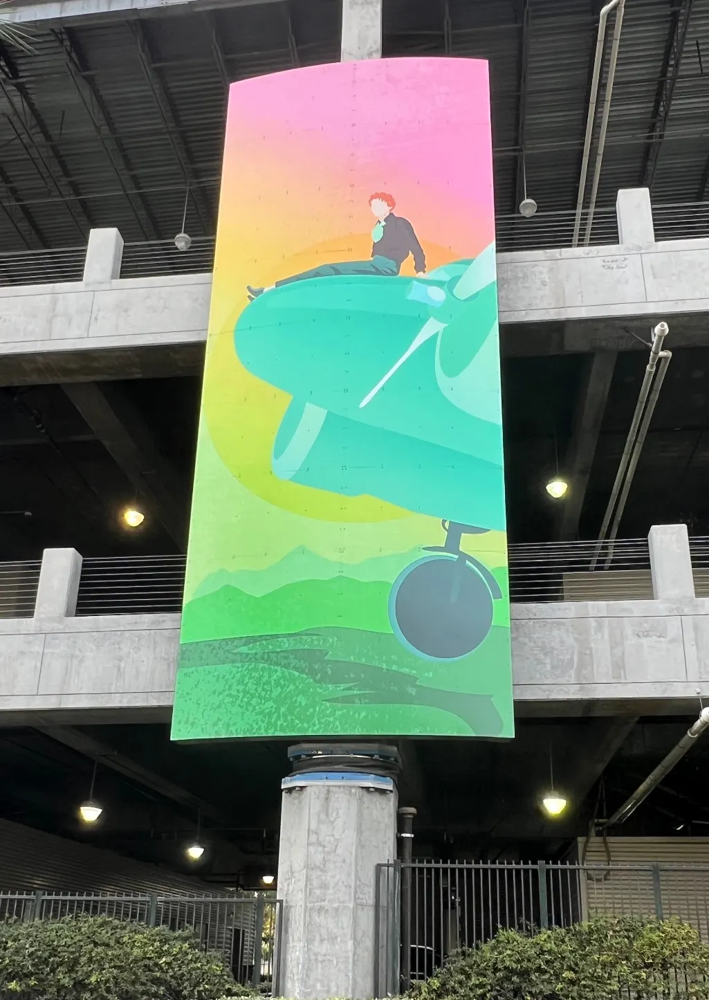 Large-format printed banner installed on a parking structure.