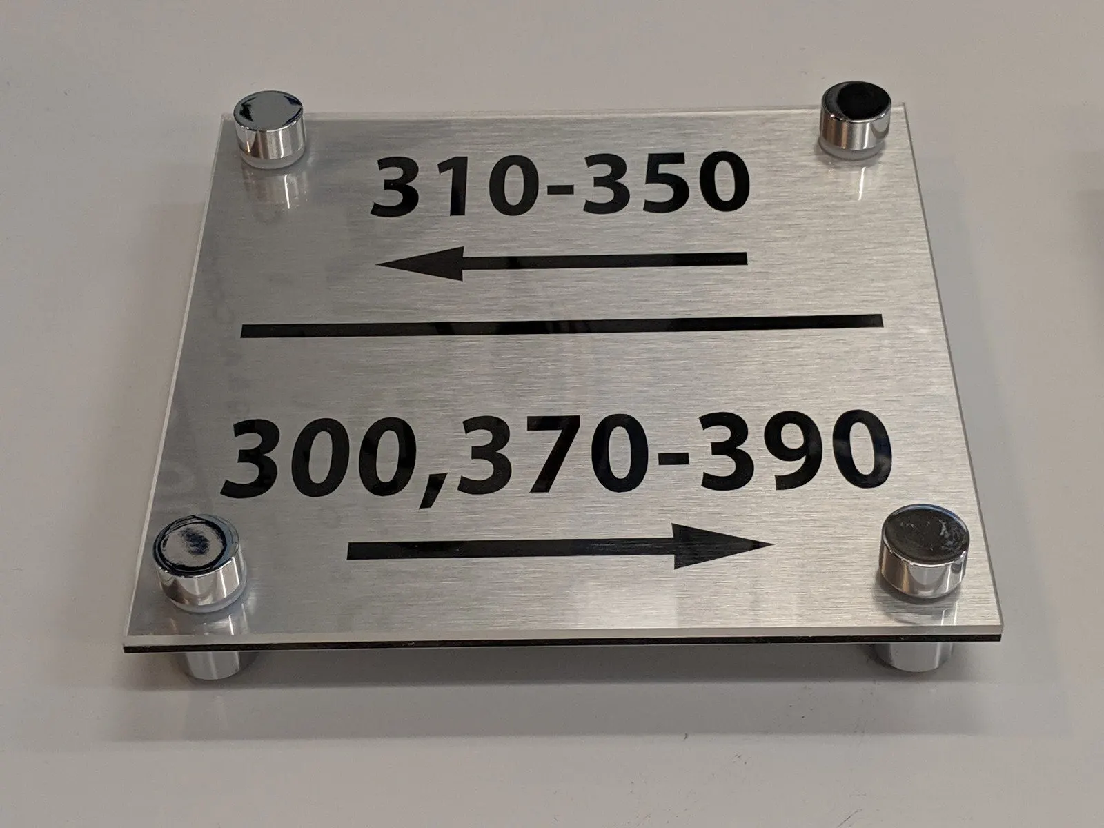 Brushed plate on standoffs with arrows.