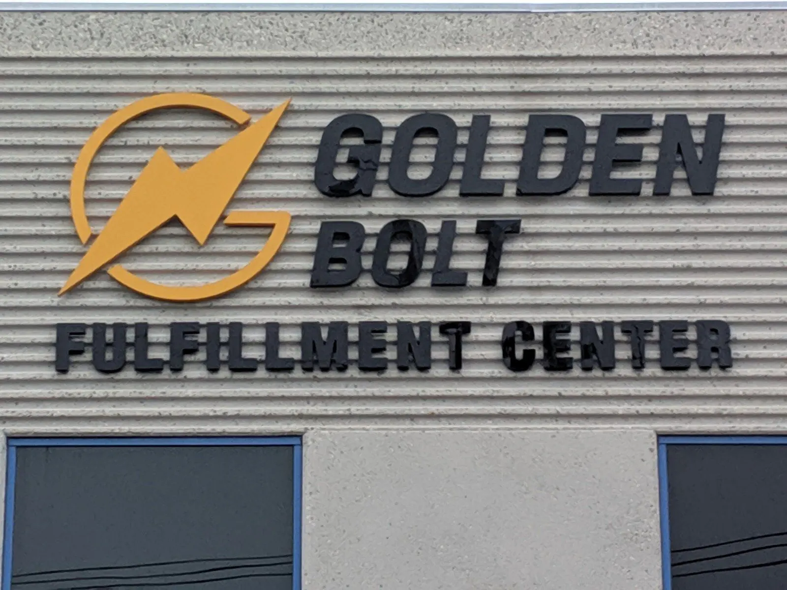 Logo and letters over the entrance of a warehouse.