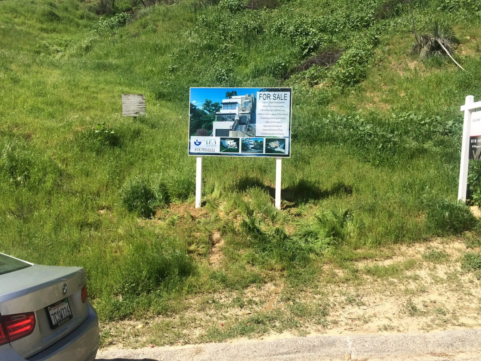 Two post-and-panel signs for a property listing.