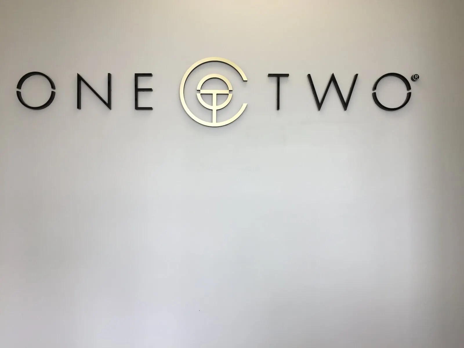 Thin dimensional letters and a logo mark.