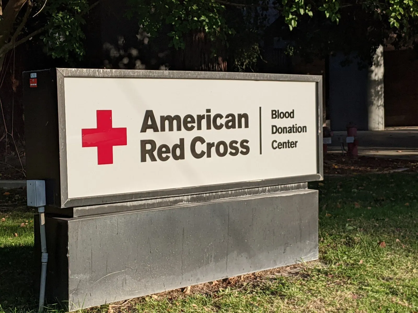 Blood donation center identification, panel on a concrete base.