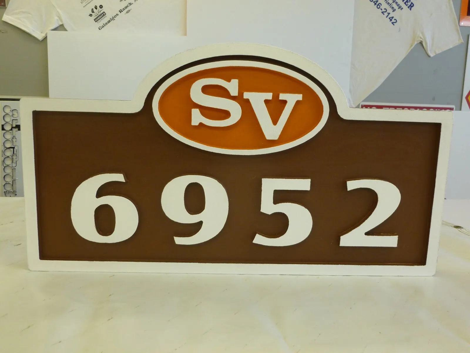 Routed address panel with a painted logo.